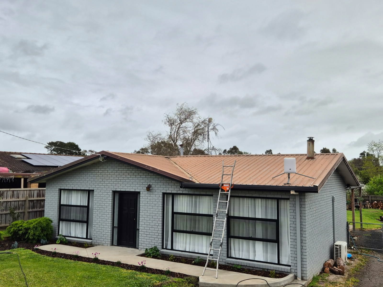 Faded oxidised tan metal roof before restoration