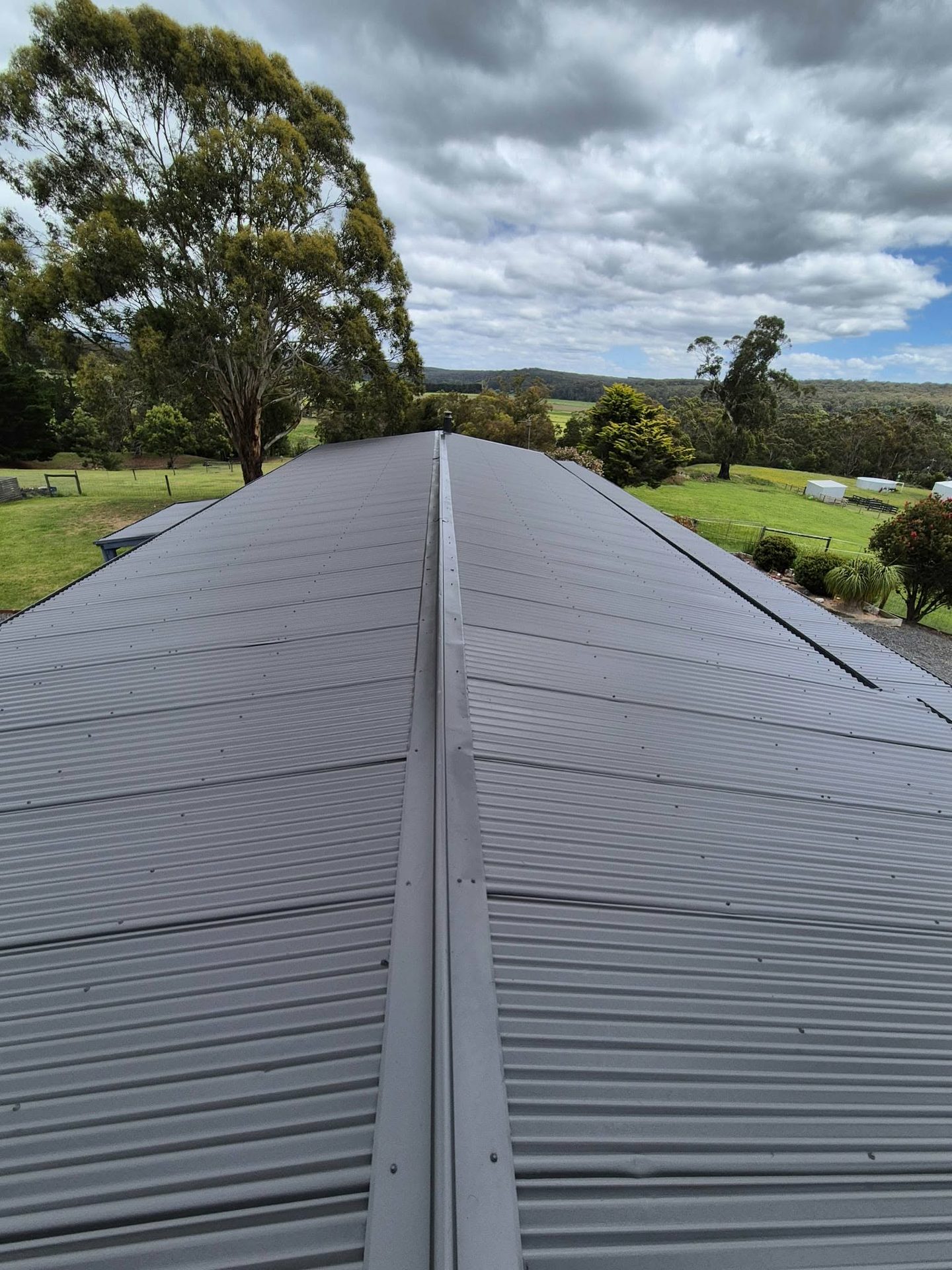 Corrugated metal roof recoated to a clean uniform finish