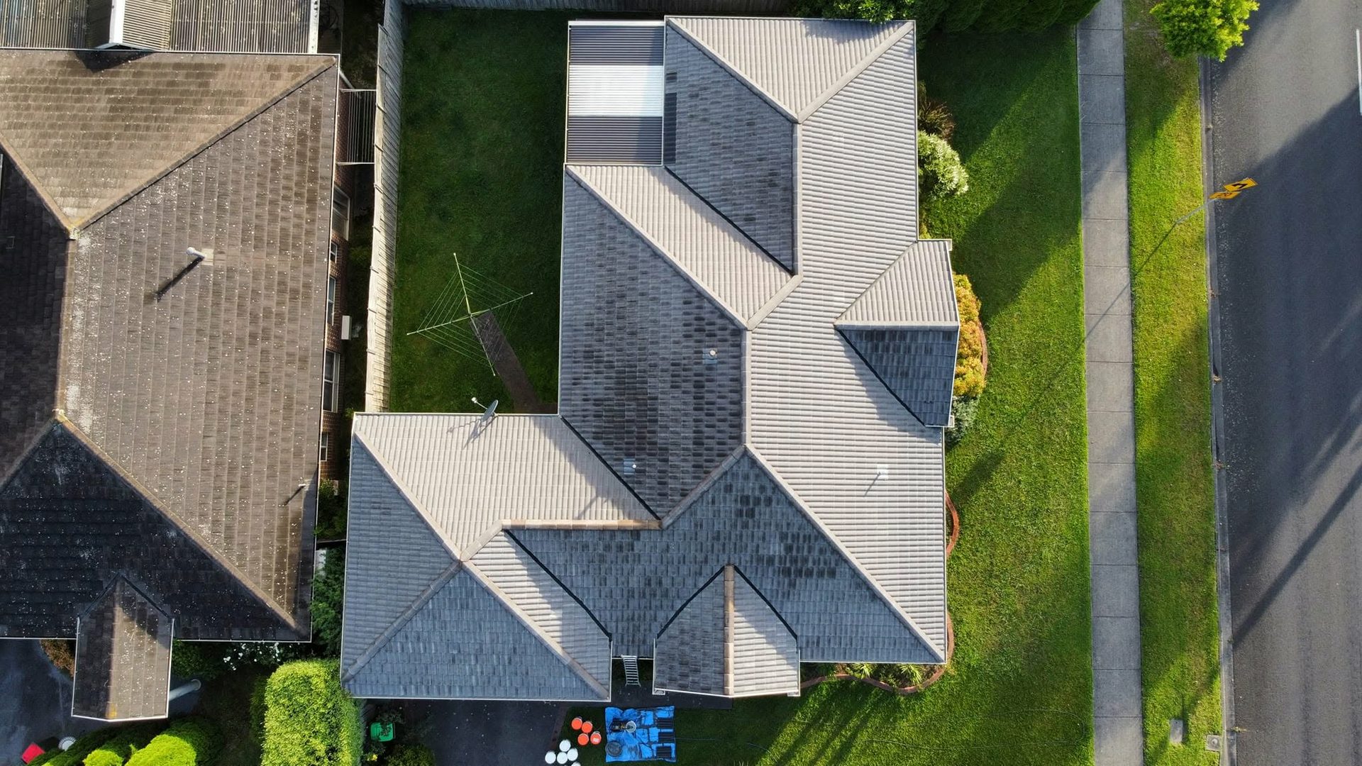 Aerial view of weathered, mottled concrete tile roof before restoration