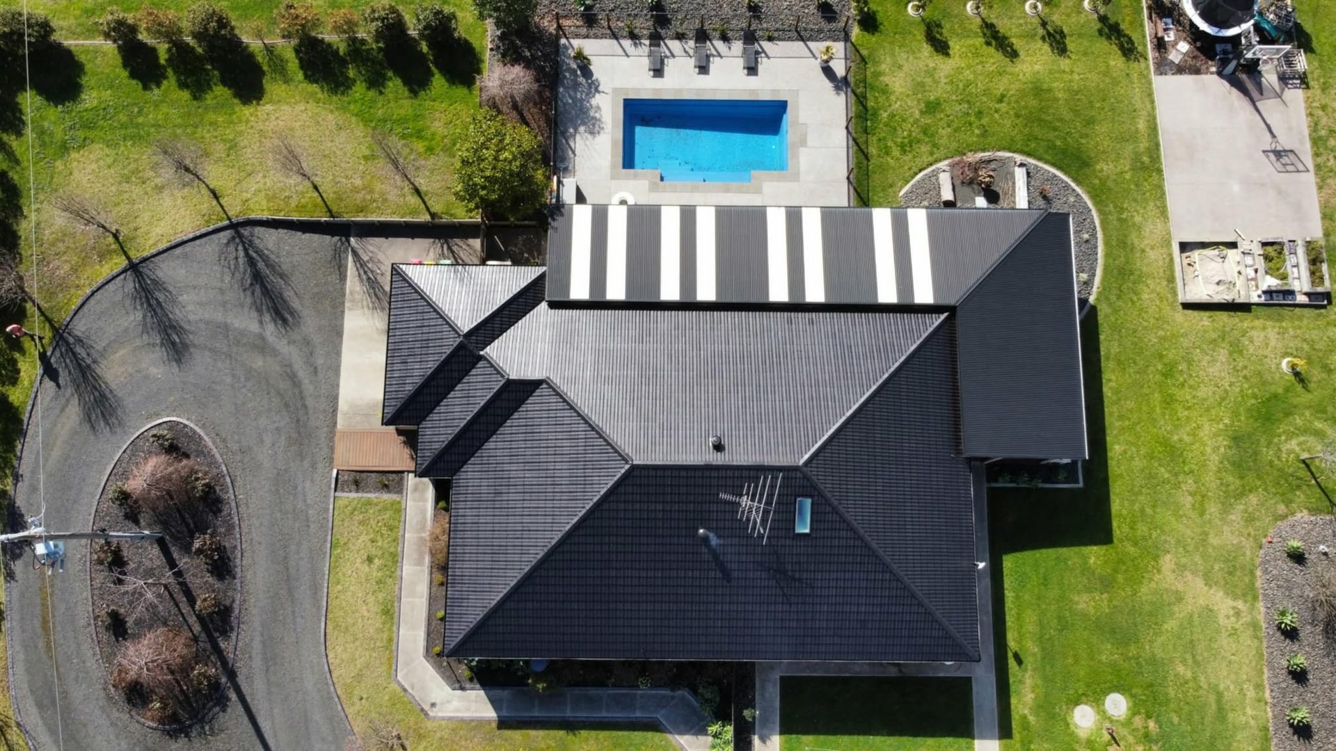 Aerial view of the same home's tile roof restored in crisp black